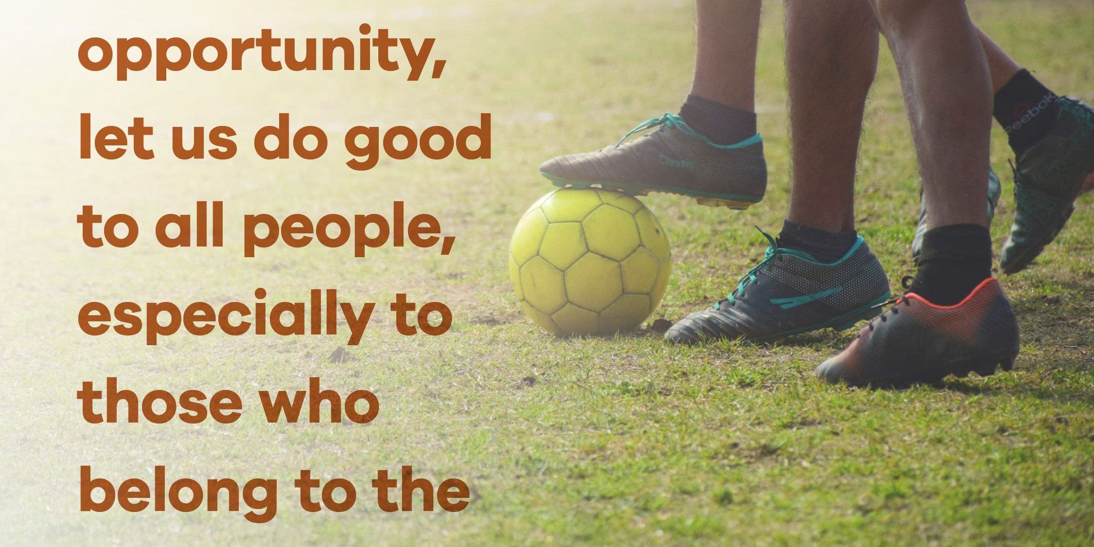 An excerpt of the daily verse to the left of the legs of soccer players fighting over a yellow ball