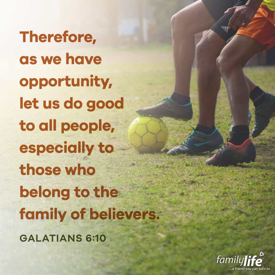 Daily-Verse_7-22-25 An excerpt of the daily verse to the left of the legs of soccer players fighting over a yellow ball